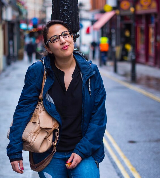 Portrait of woman standing on street in city