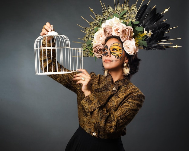 Portrait of woman in sugar skull makeup holding a cage Halloween and day of the dead makeup