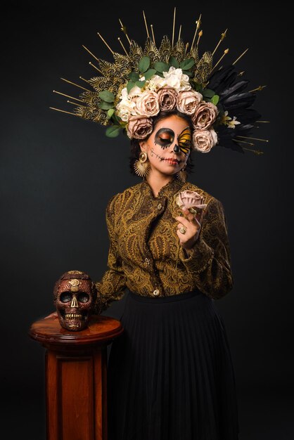 Portrait of woman in sugar skull makeup holding a skull Catrina portrait