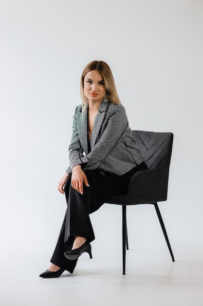 portrait of a woman in a suit on a chair