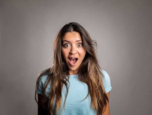 Photo portrait of woman surprised on gray