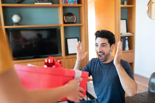 Portrait of a woman surprising her boyfriend with a present.