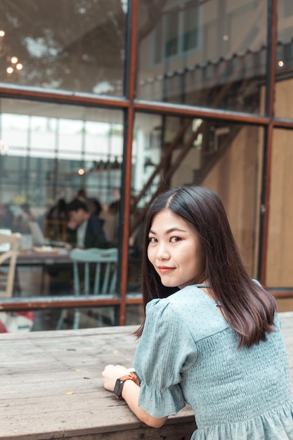 Photo portrait of woman at table against cafe