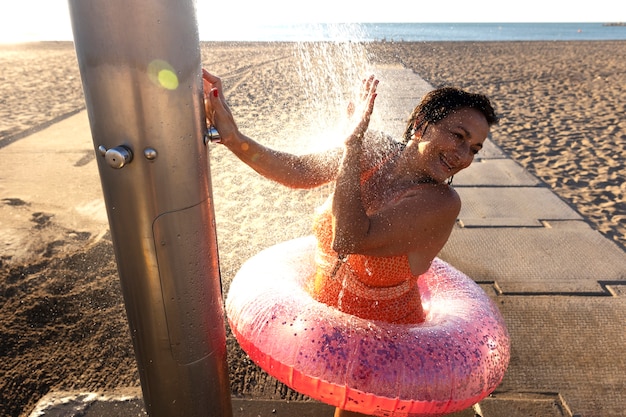 Foto ritratto di donna che fa la doccia sulla spiaggia