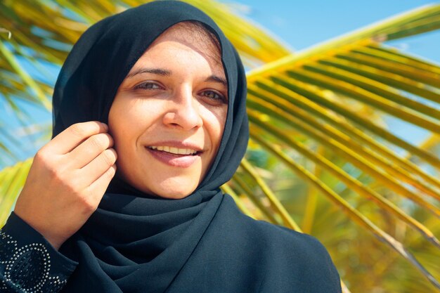 Portrait of woman in traditional clothing against palm tree