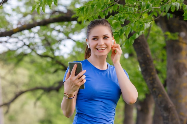 portrait woman training in park, and listening to music