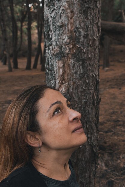 Foto ritratto di una donna sul tronco di un albero