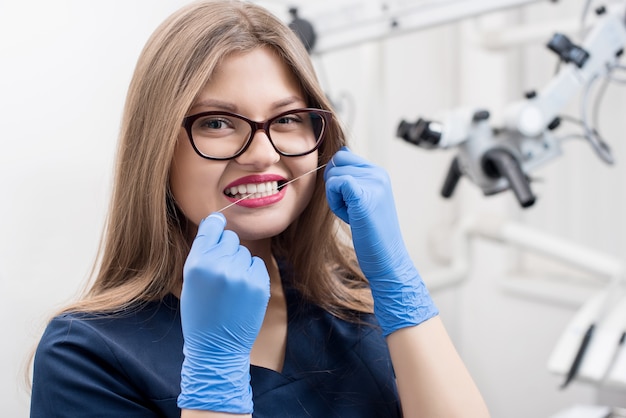 Portrait of a woman using dental floss