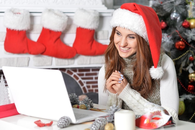 Portrait of woman using laptop preparing for Christmas