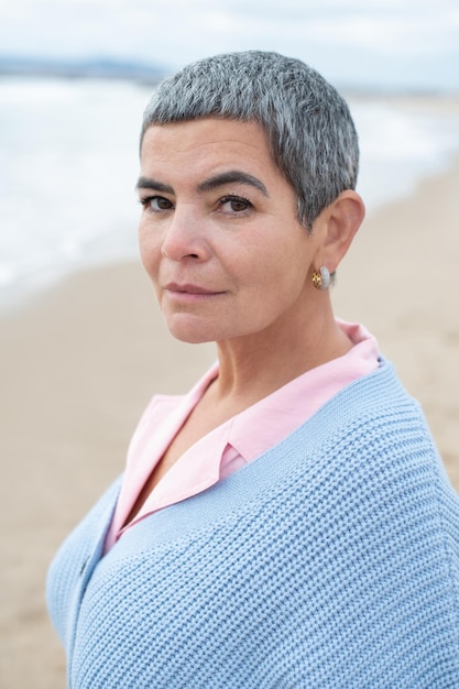 Portrait of woman walking near sea. Female model with short hair having walk on cloudy day. Nature, spare time concept