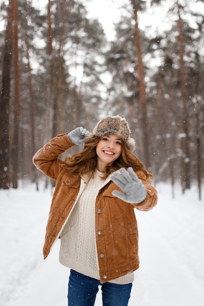 Portrait woman walking in a snowy forest in winter