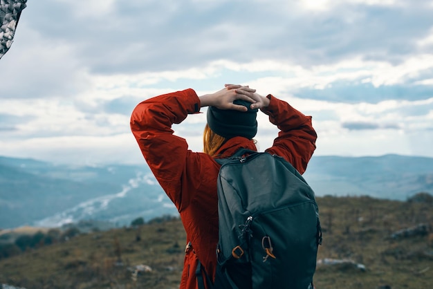 Portrait of a woman in warm clothes in the mountains in autumn landscape tourism