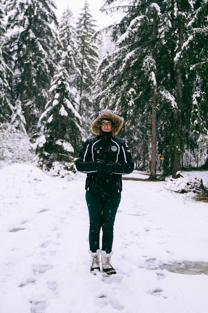 雪地に立っている暖かい服を着た女性の肖像画