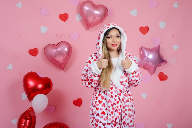 Portrait of woman wearing bathrobe with heart shaped figures with positive attitude