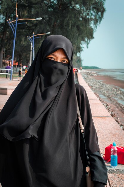 Foto ritratto di una donna che indossa il burka in piedi sul marciapiede