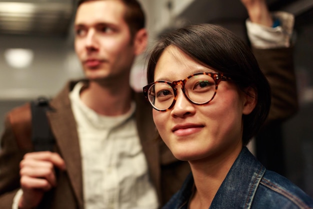 Portrait of woman wearing eyeglasses while standing with man