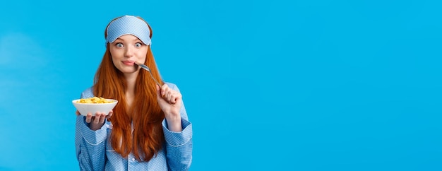 Portrait of woman wearing hat against blue background