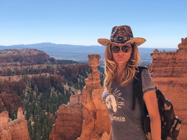 Portrait of woman wearing hat against rocky mountains at bryce canyon