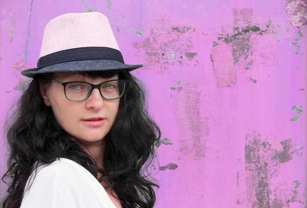 Portrait of woman wearing hat against wall