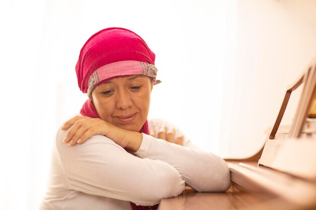 Foto ritratto di una donna che indossa un cappello seduta a casa