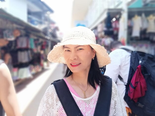 Portrait of woman wearing hat standing at market