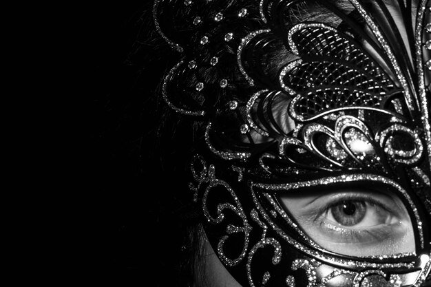 Photo portrait of woman wearing mask against black background