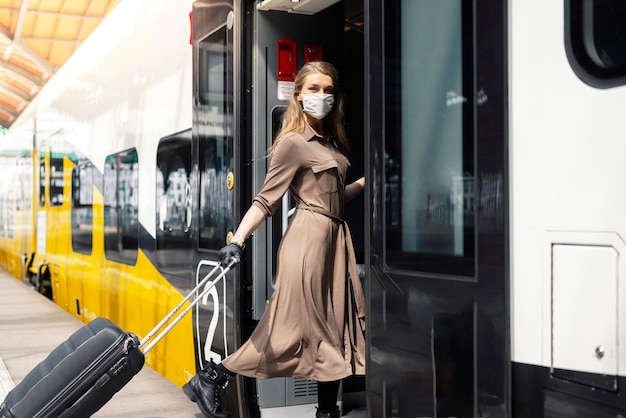 Photo portrait of woman wearing mask entering in train