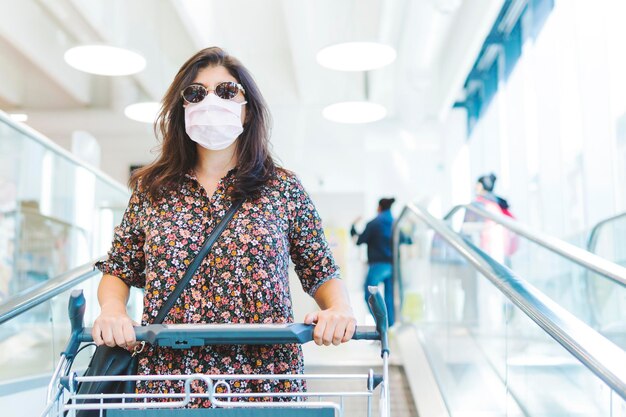 Portrait woman wearing mask standing in supermarket