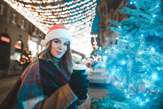 Photo portrait woman wearing santa hat holding cup of coffee