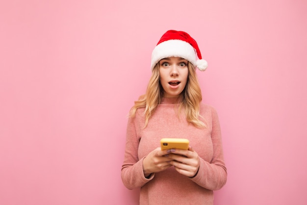 portrait woman wearing Santa hat with phone
