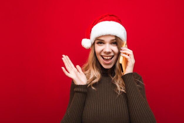 portrait woman wearing Santa hat with phone