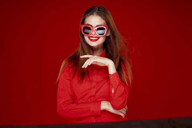 Photo portrait of woman wearing sunglasses against yellow background