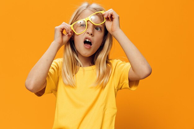 Portrait of woman wearing sunglasses against yellow background