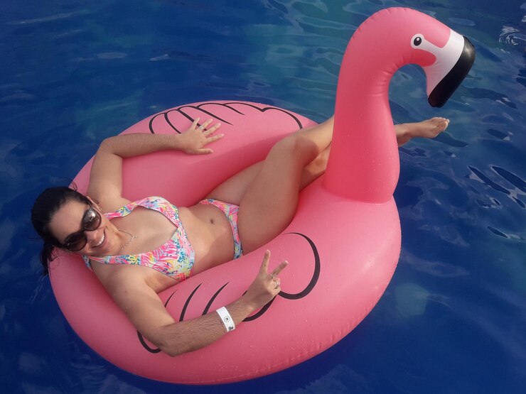 Photo portrait of woman wearing sunglasses in inflatable ring floating on water