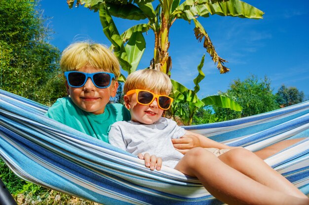 Photo portrait of woman wearing sunglasses while sitting on beach