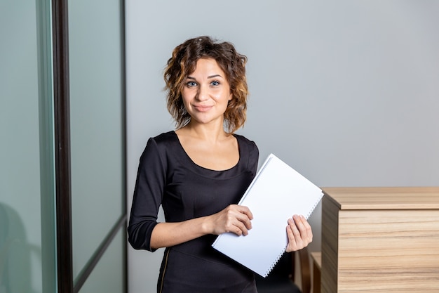 Portrait of woman in white office with documents isolated.