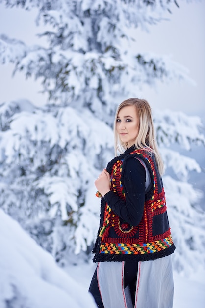 Portrait of woman on winter day on snowy landscape background