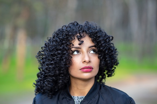 屋外でアフロヘアーを持つ女性の肖像画