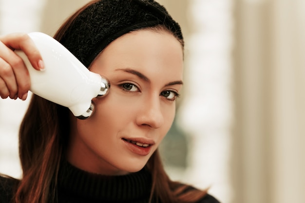 Portrait of a woman with a beauty gadget.