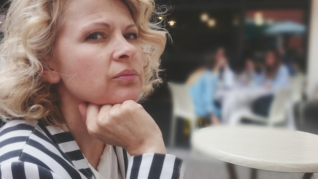 Портрет женщины с светлыми волосами в кафе