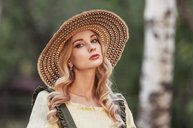 Portrait of a woman with blonde hair in retro clothes in a park or garden