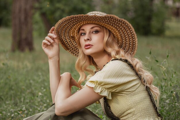 Portrait of a woman with blonde hair in retro clothes in a park or garden