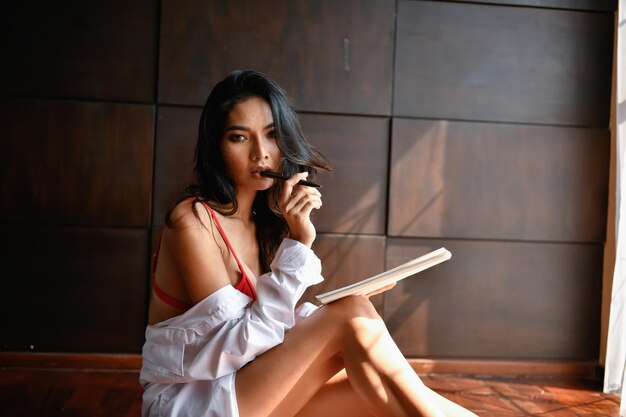 Portrait of woman with book while sitting at home