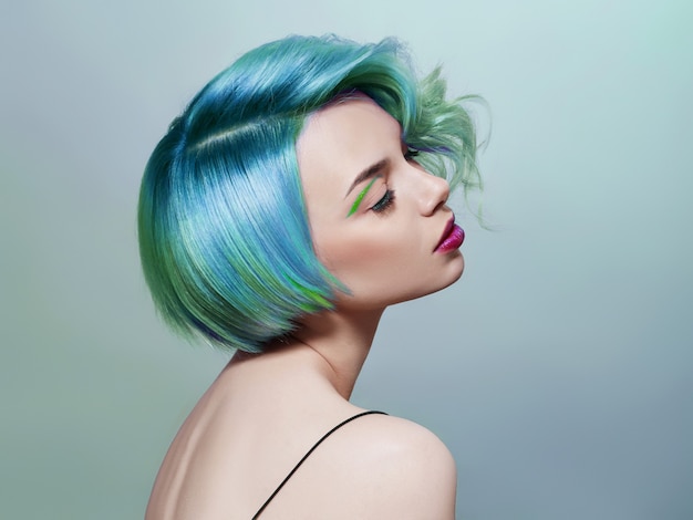 Portrait of a woman with bright colored flying hair, all shades of blue purple. Hair coloring, beautiful makeup