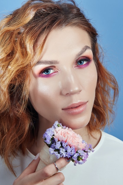 Portrait of a woman with bright red shadows on her eyes and perfect makeup on her face. 