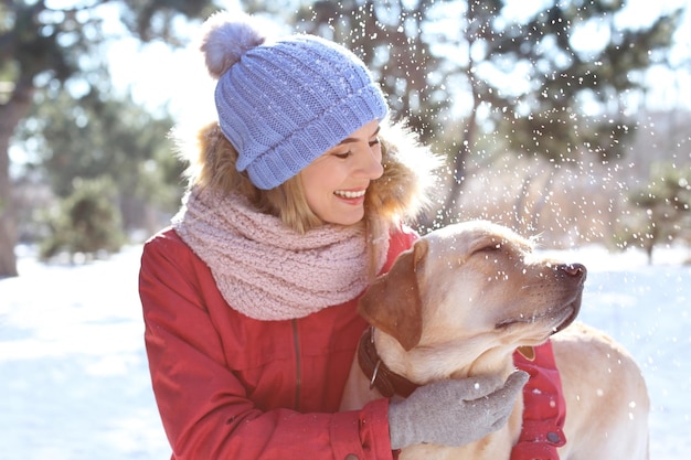 Portrait of woman with cute dog outdoors on winter day Friendship between pet and owner