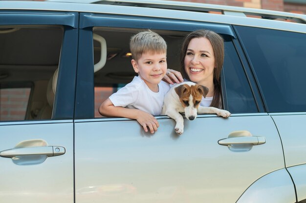 Portrait of woman with dog on car