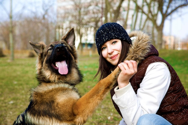 Foto ritratto di una donna con un cane accovacciato sull'erba