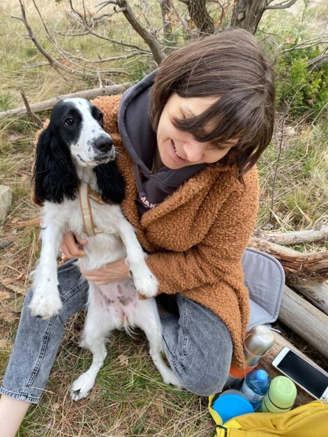 Foto ritratto di una donna con un cane sul campo