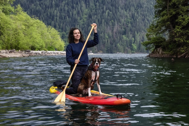 Photo portrait of woman with dog in lake